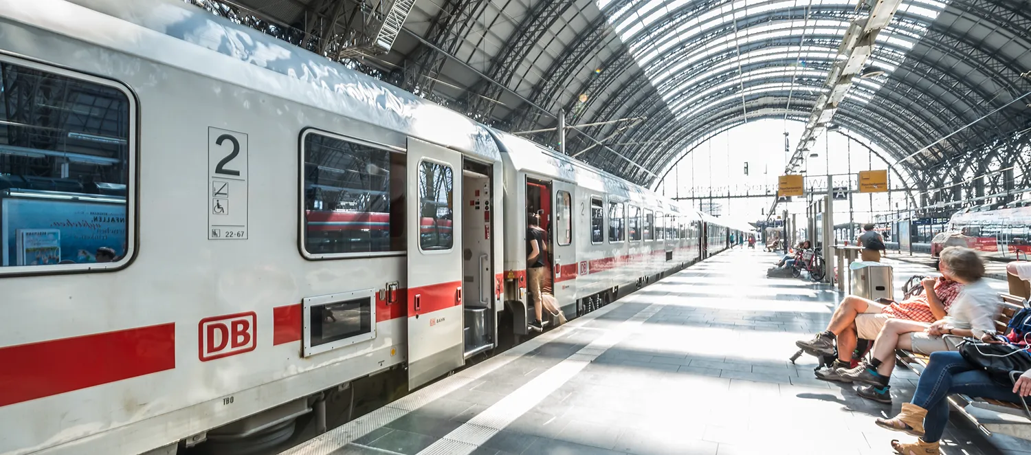 Zug steht an einem Bahngleis 