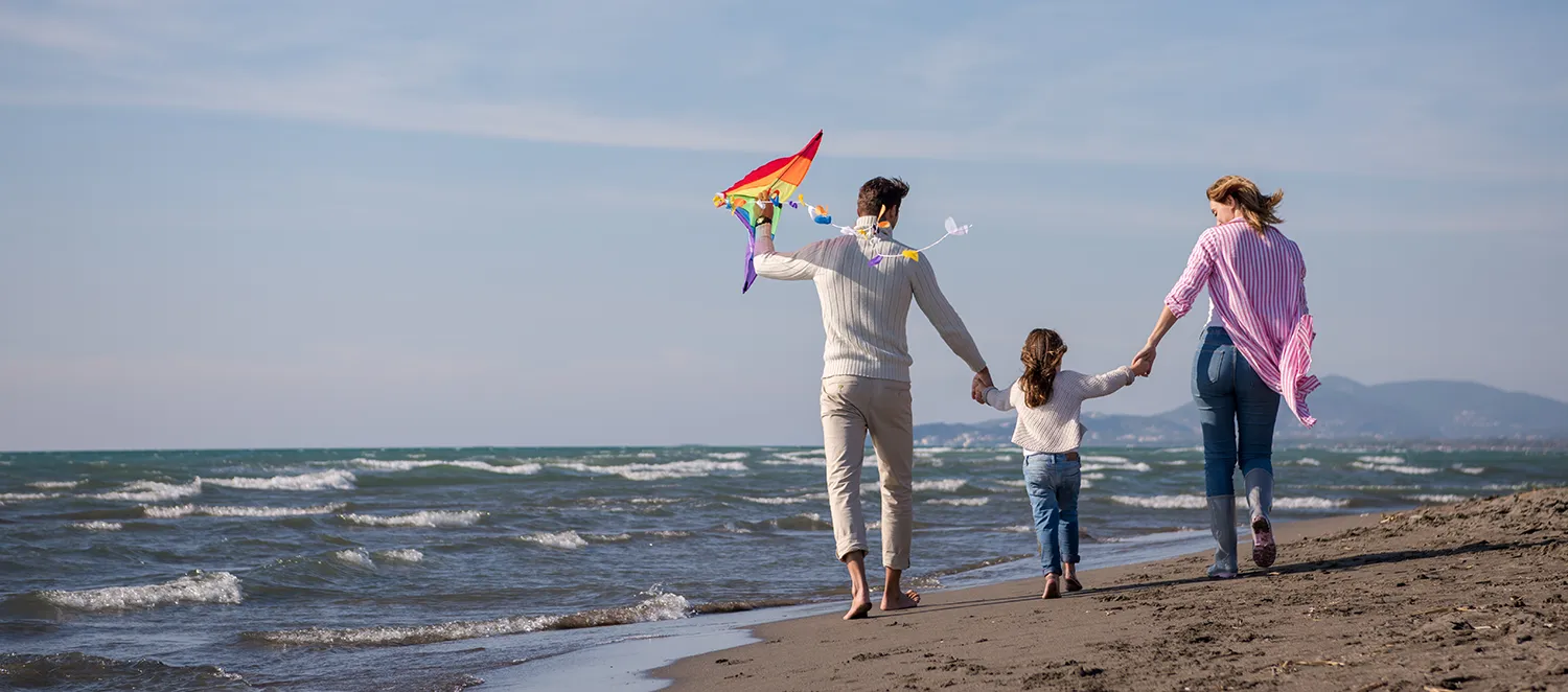 Familie ist zum Drachensteigen an einem Strand