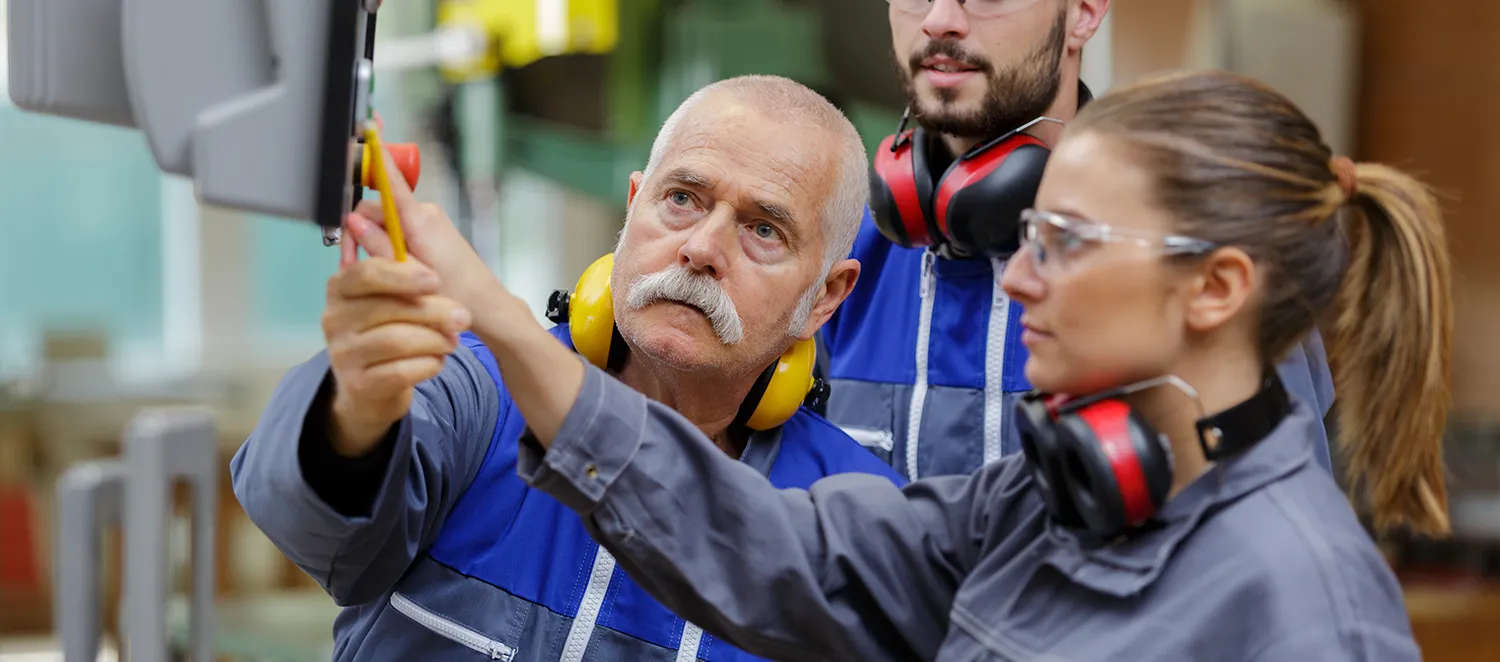 Mitarbeiter arbeiten gemeinsam an einer Maschine 