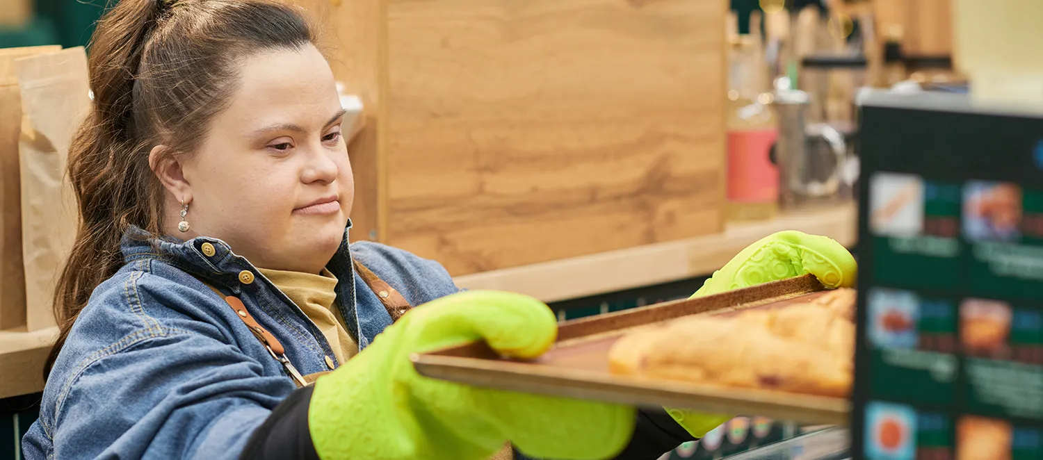 Frau mit Behinderung arbeitet in einer Bäckerei 